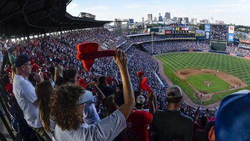 Atlanta Braves fans cheer with a tomahawk chop during the ninth inning of a baseball game against the Detroit Tigers, and the Braves' final game at Turner Field, Sunday, Oct. 2, 2016, in Atlanta. The franchise is planning on starting next season at SunTrust Park which is under construction in Cobb County. (AP Photo/John Amis)