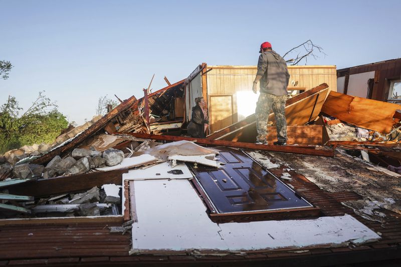 People look through a damaged property after powerful storms hit the area, Tuesday, May 7, 2024 in Barnsdall, Okla. (Mike Simons/Tulsa World via AP)