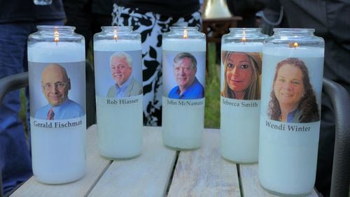 In this file photo from June 29, 2018, candles honoring Gerald Fischman, Rob Hiassen, John McNamara, Rebecca Smith, and Wendi Winters flicker as the sun sets during a candlelight vigil at Annapolis Mall for the five Capital Gazette employees slain during a shooting spree in their newsroom.