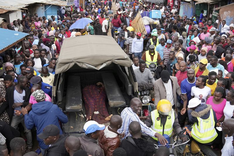 Residents gather around the covered dead body of a woman retrieved from a house, after heavy rain in the Mathare slum of Nairobi, Kenya, Wednesday, Apr. 24, 2024. Heavy rains pounding different parts of Kenya have led to the deaths of at least 35 people since mid-March and displaced more than 40,000 people, according to the U.N., which cites Red Cross figures in the most recent update. (AP Photo/Brian Inganga)