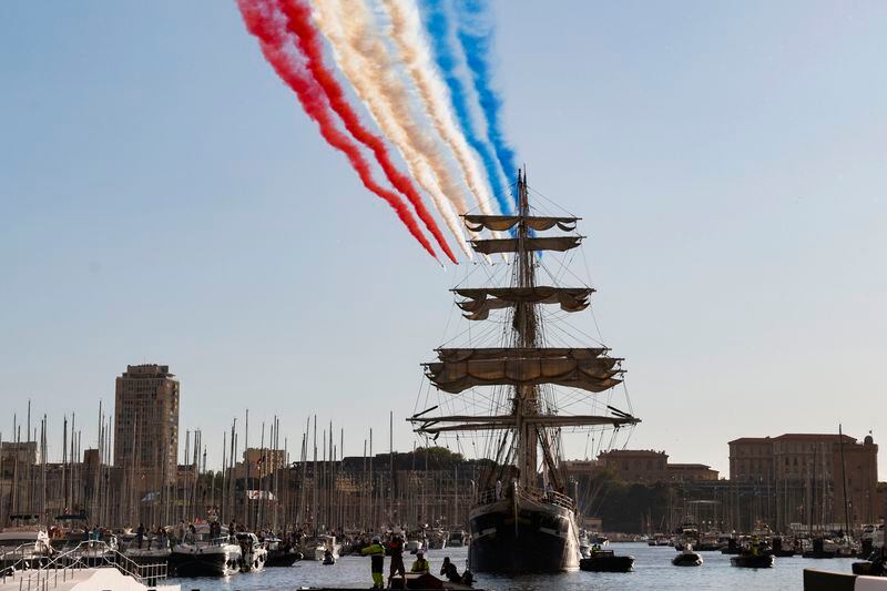 The French acrobatic flying team Patrouille de France flies over the French 19th-century three-mast ship Belem during the torch arrival ceremony in Marseille, southern France, Wednesday May 8, 2024. The Olympic flame arrived in Marseille's Old Port Wednesday on a majestic three-mast ship from Greece for the welcoming ceremony at sunset in the city's Old Port. (Ludovic Marin, Pool via AP)