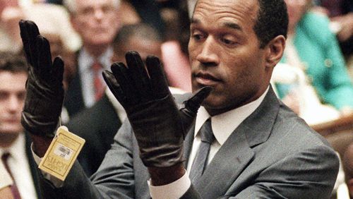 In this June 21, 1995 file photo, O.J. Simpson holds up his hands before the jury after putting on a new pair of gloves similar to the infamous bloody gloves during his double-murder trial in Los Angeles. Simpson, the decorated football superstar and Hollywood actor who was acquitted of charges he killed his former wife and her friend but later found liable in a separate civil trial, has died. He was 76. (Vince Bucci/Pool Photo via AP, File)