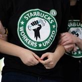 FILE - Starbucks employees and supporters link arms during a union election watch party Dec. 9, 2021, in Buffalo, N.Y. The U.S. Supreme Court is set to hear oral arguments in a case filed by Starbucks against the National Labor Relations Board. (AP Photo/Joshua Bessex, File)