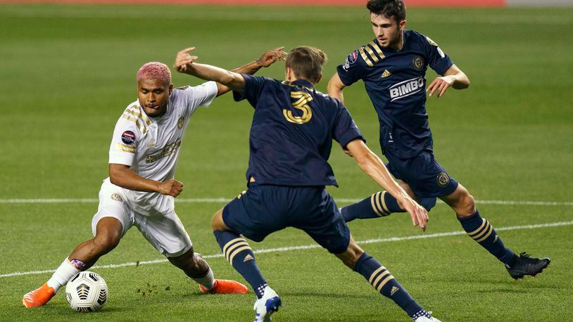 Atlanta United's Josef Martinez, left, battles with Philadelphia Union's Jack Elliott, center, for the ball as Philadelphia Union's Leon Flach, right, looks on during the first half of a CONCACAF Champions League soccer match, Tuesday, May 4, 2021, in Chester, Pa. (AP Photo/Chris Szagola)