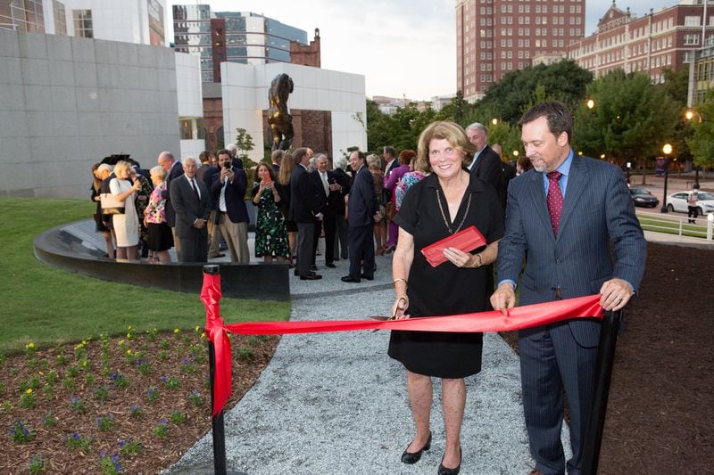 Susan Virgin cuts the ribbon to a new path on the Woodruff Arts Center campus. It leads to L’Ombre (“The Shade”), a Rodin sculpture given to the city of Atlanta, which stands at the edge of the campus, above Peachtree Street. CONTRIBUTED BY WOODRUFF ARTS CENTER