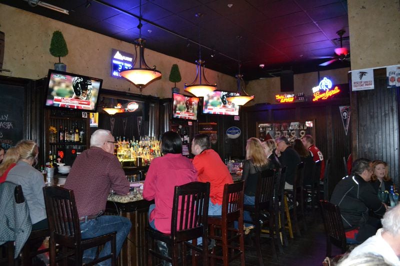 Fans sit at the back bar of McCray's Tavern in Smyrna, Ga. and watch NFL Fox Pregame before the start of the Falcons-Packers in the NFC Championship Game.