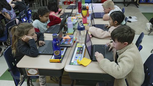 Emmie Gotz (left) and Jackson Bansbach, students in Heather Sonmez's second grade class, work on Chromebooks with classmates at Brookwood Elementary School in Cumming on Monday, March 28, 2022.   (Bob Andres / robert.andres@ajc.com)