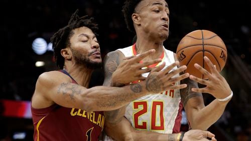 Atlanta Hawks' John Collins (20) and Cleveland Cavaliers' Derrick Rose (1) battle for the ball in the first half of an NBA basketball game Sunday, Nov. 5, 2017, in Cleveland. (AP Photo/Tony Dejak)