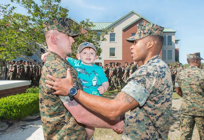 Sgt. Tyler Harman, left, holds his son Mason, 3, while being congratulated for being awarded the Navy & Marine Corps Achievement Medal during a ceremony at the Pensacola Naval Air Station on Thursday, April 12, 2018. On February 1st, Harman saved his 2-year-old neighbor Rylan Strother's life when he was choking on a grape.