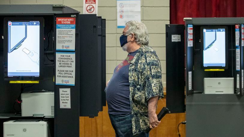 Doug Kaye of the North Ormewood Park neighborhood casts his vote at the Lang Carson Community Center in Atlanta's Reynoldstown community Sept. 29.  (Alyssa Pointer / Alyssa.Pointer@ajc.com)