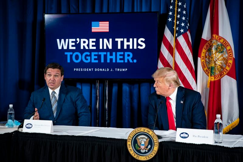 President Donald Trump listens as Florida Gov. Ron DeSantis, left, speaks as then-President Donald Trump listends during a coronavirus response and storm preparedness roundtable in Belleair, Fla., in July 2020. The two men are now considered top contenders for the Republican presidential nomination in 2024. (Al Drago/The New York Times)
                      
