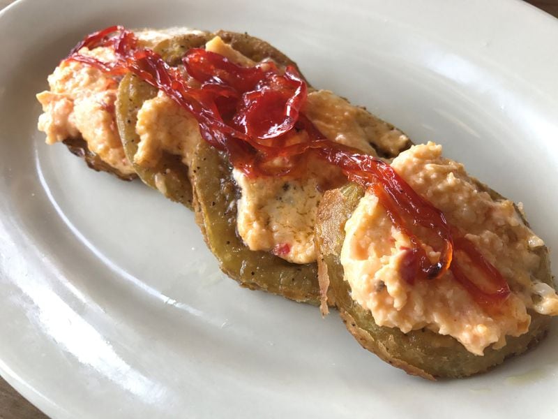 At Radial Cafe, Doux South pickled tomatoes lend unexpected tang to fried green tomatoes topped with pimento cheese and red pepper jelly. LIGAYA FIGUERAS / LFIGUERAS@AJC.COM