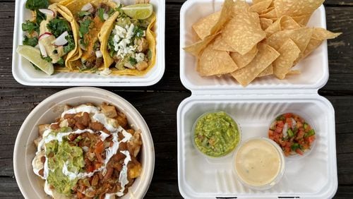 A takeout spread from the Queso Truck: clockwise from upper left: chicken, carne asada and pork belly tacos; the trio with queso, salsa, guacamole and house-made chips; loaded tots with pork belly. 
Wendell Brock for The Atlanta Journal-Constitution