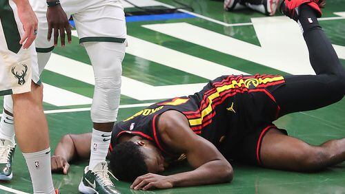 Hawks' Onyeka Okungwu is knocked to the hardwood with a hard foul.   “Curtis Compton / Curtis.Compton@ajc.com”