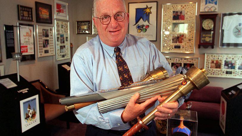 Public relations icon Bob Cohn in 1996 with some of the many Olympic torches he collected over the years. Cohn died Tuesday in Alabama at age 88. AJC FILE PHOTO.