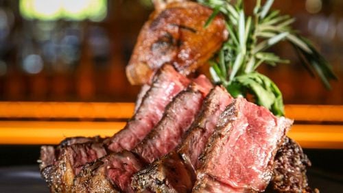A tomahawk rib-eye is one of many steaks served at the Meat Market in Palm Beach, Fla. CONTRIBUTED BY BEN RUSNAK