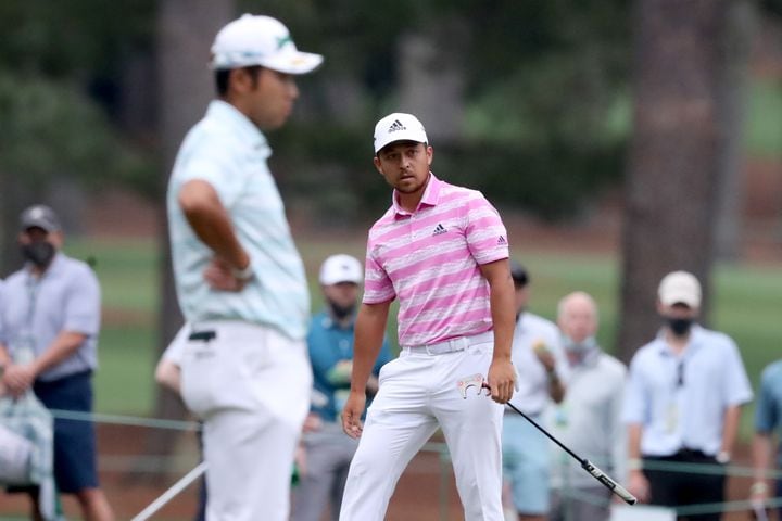 April 10, 2021, Augusta: Xander Schauffele makes an eagle putt as Hideki Matsuyama, left, watches on the fifteenth hole during the third round of the Masters at Augusta National Golf Club on Saturday, April 10, 2021, in Augusta. Curtis Compton/ccompton@ajc.com