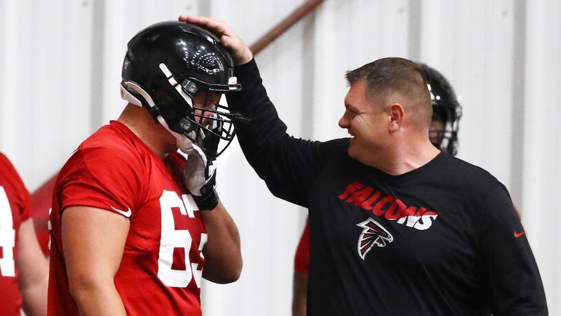 Atlanta Falcons offensive line coach Chris Morgan gives first-round draft pick Chris Landstrom a pat on the helmet after a blocking drill during rookie minicamp Saturday, May 11, 2019, in Flowery Branch.