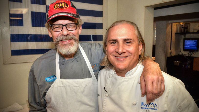 After sharing a few old kitchen war stories, Chef Tenney Flynn (left) poses on July 26, 2019, with old friend and former co-worker Pano I. Karatassos in the kitchen of Kyma in Buckhead where Karatassos is executive chef. CHRIS HUNT PHOTOGRAPHY
