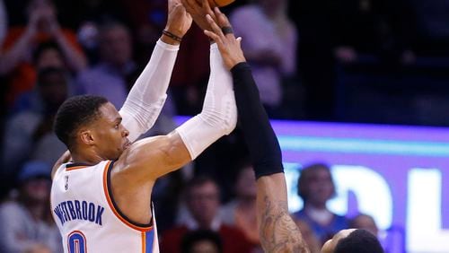 Oklahoma City Thunder guard Russell Westbrook (0) attempts a 3-point basket in front of Atlanta Hawks forward Kent Bazemore (24) in the final seconds of the fourth quarter of an NBA basketball game in Oklahoma City, Monday, Dec. 19, 2016, but misses the shot. Atlanta won 110-108. (AP Photo/Sue Ogrocki)
