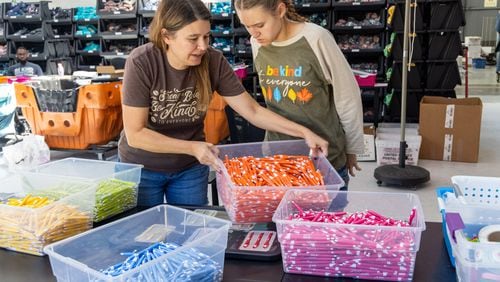 Jackie Moore (left) helps set up a work station for her daughter Jordyn at the Summer Shirt Project warehouse in Cumming. Her family started a business, the Summer Shirt Project, to create a job that Jordyn, who has autism, could thrive in. PHIL SKINNER FOR THE ATLANTA JOURNAL-CONSTITUTION