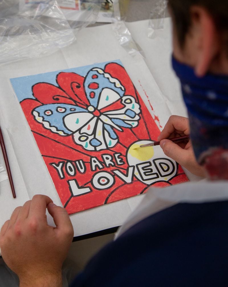 St. Pius X Catholic School football player Liam Klosky paints a heart board to show his support and appreciation to healthcare workers. PHIL SKINNER FOR THE ATLANTA JOURNAL-CONSTITUTION.