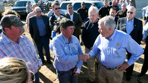 Gov. Nathan Deal, right, shakes hands Wednesday with Jeff Bullard, 49, who lost his home in Adel during the storms that hit South Georgia over the weekend, killing at least 15 people. Deal toured the damaged areas and spoke to victims. (DAVID BARNES / DAVID.BARNES@AJC.COM)