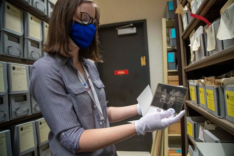 Georgia State University library photographic associate Michelle Asci shows a photograph printed on glass of Georgia Tech football players from 1930. The glass negative is part of a collection of 10 million images in the Georgia State University archive. (Alyssa Pointer/Atlanta Journal Constitution).