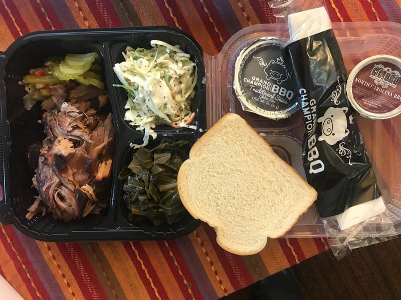 A pork plate from Grand Champion BBQ comes with two sides, two sauces, pickles and a slice of bread. LIGAYA FIGUERAS / LIGAYA.FIGUERAS@AJC.COM