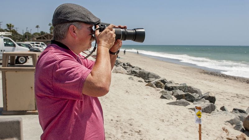 Todd Metzger of San Clemente, Calif. scans the surf on Thursday, May 11, 2017 at Capistrano Beach looking for sharks to photograph in Dana Point. (Paul Rodriguez/Orange County Register/TNS)