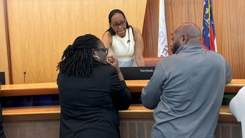 Riverdale residents Josie Singletary (left) and Isiah Lester (right) speak with Riverdale City Councilwoman Wanda Wallace (standing) at Riverdale town hall meeting on Wednesday, April 10, 2024.