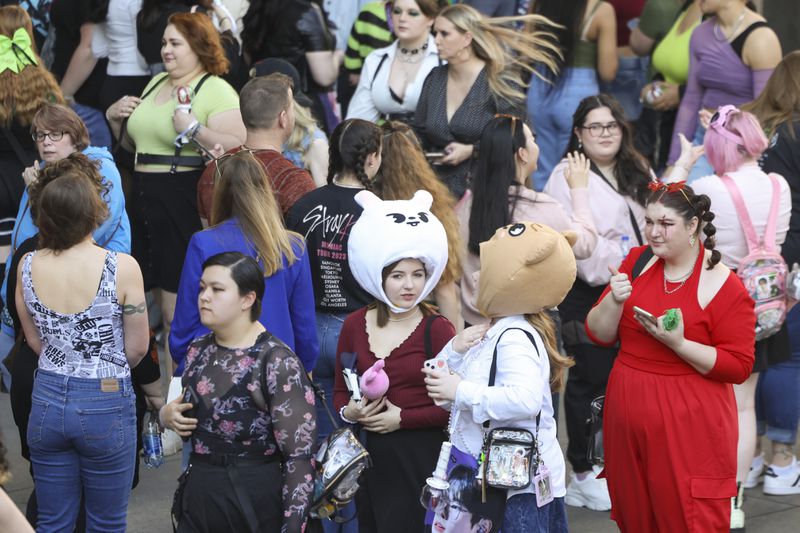 Wearing a white rabbit hat, Brittani Thomas of North Carolina and Lily Guffey of Mississippi, wearing a puppy hat, line up outside of State Farm Arena before the K-Pop band Stray Kids concert in March. Jason Getz / Jason.Getz@ajc.com)
