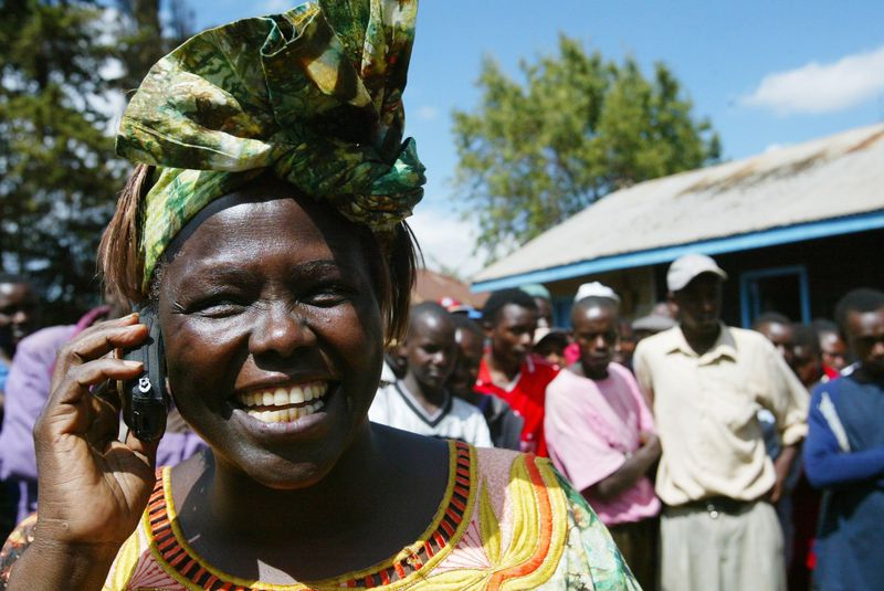 Kenyan environmental activist Wangari Maathai speaks on the phone in October 2004 in the Ihururu settlement near Nyeri, Kenya, as she is congratulated on winning the Nobel Peace Prize for her work as leader of the Green Belt Movement. (AP Photo/Karel Prinsloo)