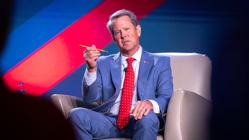 Gov. Brian Kemp, holding a pencil as a prop, speaks to WSB radio host Erick Erickson at The Gathering conservative political conference in Buckhead on Friday, August 18, 2023. (Arvin Temkar / arvin.temkar@ajc.com)