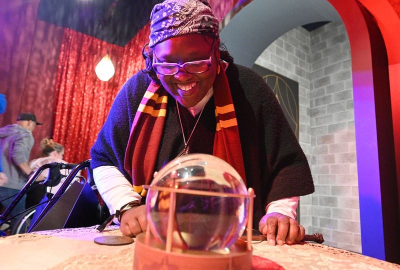 Sonjan Williams reacts as she looks into a crystal ball at 200 Peachtree Street in downtown Atlanta on Friday, October 21, 2022. Created by Atlanta-based Imagine Exhibitions, “Harry Potter: The Exhibition” will take place at 200 Peachtree where Macy’s used to be located. (Hyosub Shin / Hyosub.Shin@ajc.com)