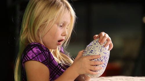 Avalyn, 6, plays with her new Hatchimal just as it begins to peck through the shell. (Richard Lautens/Toronto Star via Getty Images)