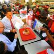 Former presidential hopeful Mitt Romney digs into the onion rings stumping in Georgia for Attorney General Sam Olens (left), joining Olens for lunch at The Varsity on Wednesday, Oct. 1, 2014, in Atlanta. CURTIS COMPTON / CCOMPTON@AJC.COM