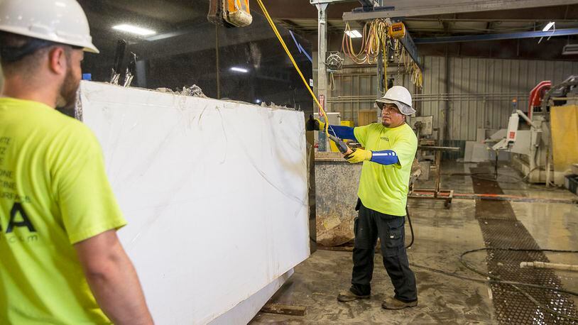 In this AJC file photo, workers handle a slab of quartz at a company in Newnan.
