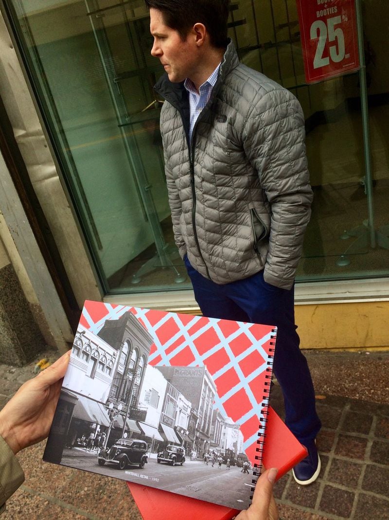 Jake Nawrocki, president of Newport US, stands on what Peachtree Street is, near a photo of what it was. Photo by Bill Torpy