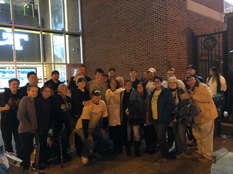 Family and friends of Georgia Tech kicker Wesley Wells outside Bobby Dodd Stadium after the Yellow Jackets' 30-27 win over Virginia on Nov. 17, 2018 in which Wells was 4-for-4 on field-goal attempts. Wells is in the center in a gray T-shirt. His mother, Sherri, is on his left and his father Eddie is crouched in front of him. (Special from Sherri Wells)