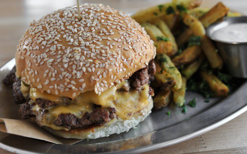 Bocado Burger Stack- American cheese, b&b pickles, mayo. Served with herb fries.
