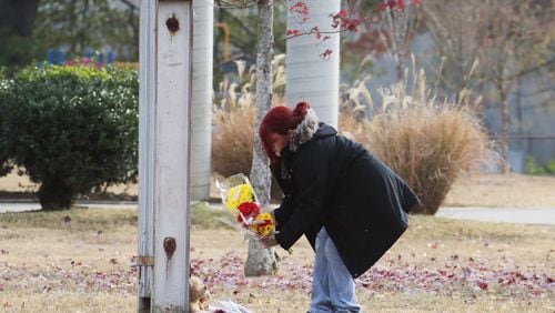 November 22, 2016 - Chattanooga - Michelle Hutto, who said her son was a friend of one of the victims and one of the injured, places flowers at Woodmore Elementary School. Two teddy bears were placed at the base of the school flag which stood at half mast. At least five children died days before Thanksgiving in a horrific crash in Chattanooga. Bus driver Johnthony Walker, 24, has been charged with five counts of vehicular homicide, reckless endangerment and reckless driving, the Chattanooga Police Department said. BOB ANDRES /BANDRES@AJC.COM