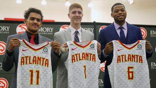 Atlanta Hawks NBA Draft first-round draft picks Trae Young (11), Kevin Huerter (1) and Omari Spellman (6) pose with their jerseys during a news conference Monday, June 25, 2018, in Atlanta.(AP photo/John Bazemore)