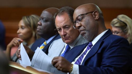 Fulton County Manager Dick Anderson and Dwight Robinson (right), Fulton County’s chief appraiser, share documentation as they listen in August 2018 during a hearing on whether Fulton County could collect tax money amid a dispute with the state over the county’s property assessments.