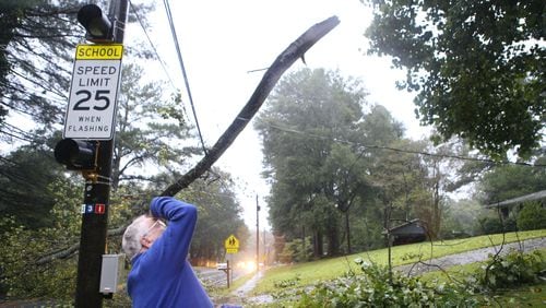 A Dekalb man looks up to find the origin point of a branch that broke off and mangled power lines on Briarcliff Road NE on Monday, September 11, 2017. As tropical storm Irma passes through Georgia, strong winds and gusts take down trees and power lines all across metro Atlanta. (Photo by Henry Taylor/henrytaylorphoto@gmail.com)