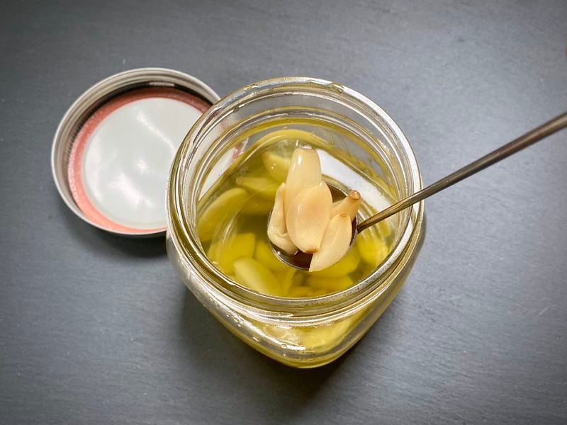 Garlic confit comes together easily in the slow cooker. The roasted garlic flavor makes any savory dish worthy of a holiday. (Kellie Hynes for The Atlanta Journal-Constitution)