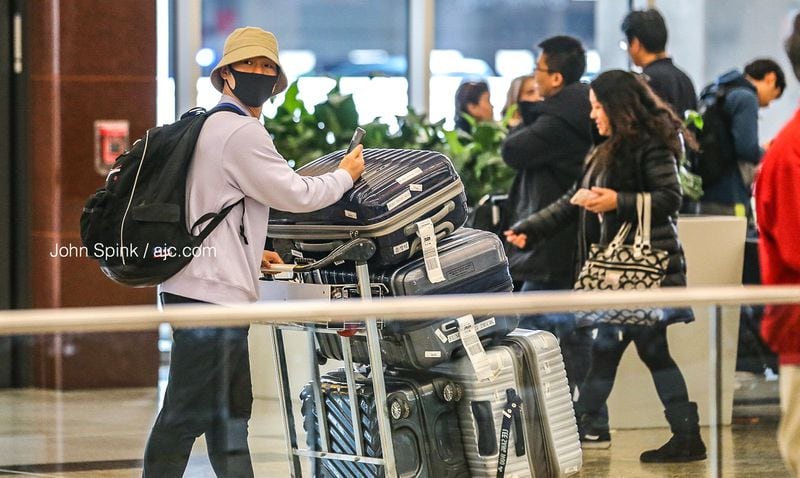 John Kim from Korea arrives at the Atlanta International Terminal wearing a mask as a precaution against coronavirus.
