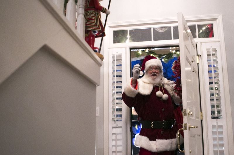 Judge T. Jackson Bedford makes his grand entrance as Santa Claus at a friend’s house Christmas party in Smyrna. CASEY SYKES / FOR THE ATLANTA JOURNAL-CONSTITUTION