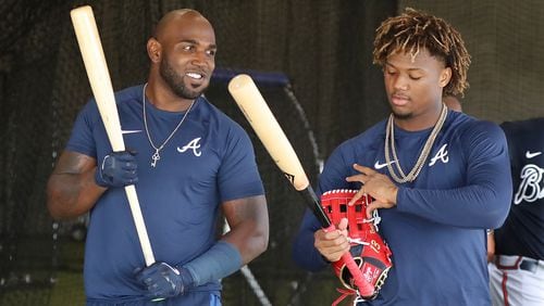Braves outfielders Marcell Ozuna (left) and Ronald Acuna (right)  talk in the batting cages at spring training last month.