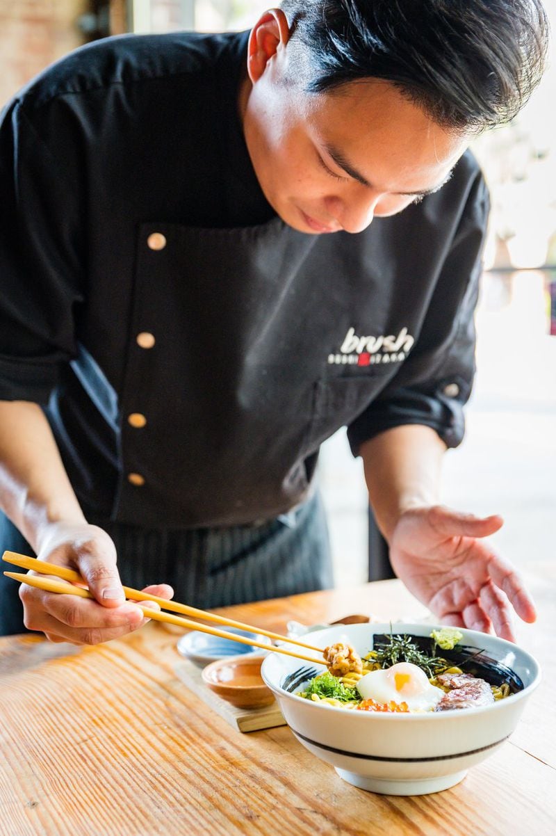Chef Jason Liang adds uni to a bowl of ramen at Brush Sushi Izakaya. (Henri Hollis for The Atlanta Journal-Constitution)